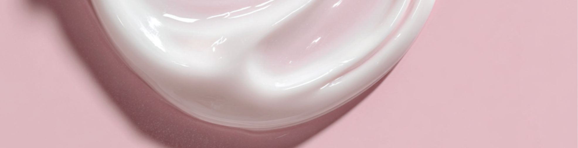 White creme or lotion on pink background