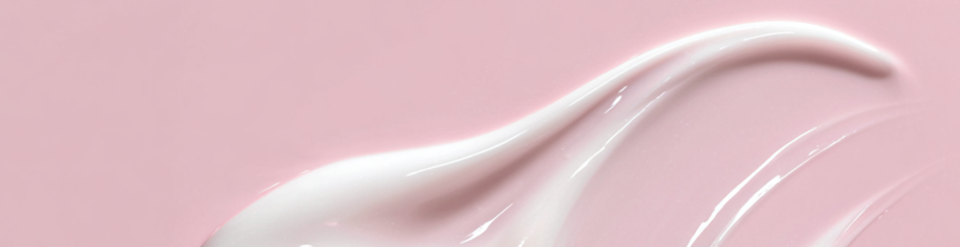 White cream or lotion swatch on a pink background